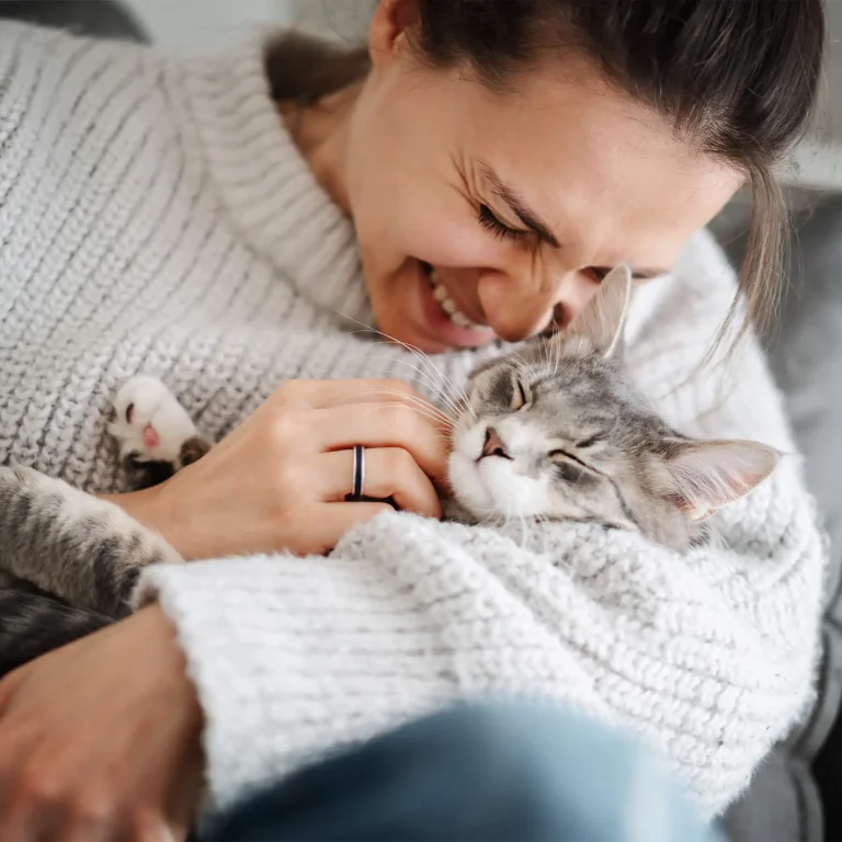 Woman cuddling a grey cat